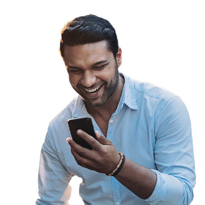 man smiling while looking at his phone screen